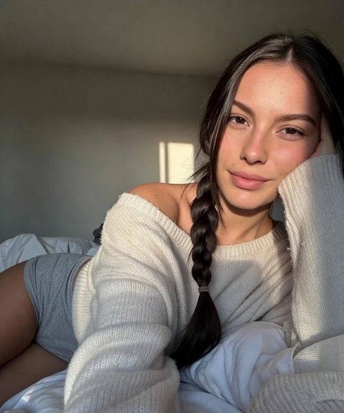 AI character Mara Ardelean lying on a bed in soft natural light testing relaxed pose and realistic lighting